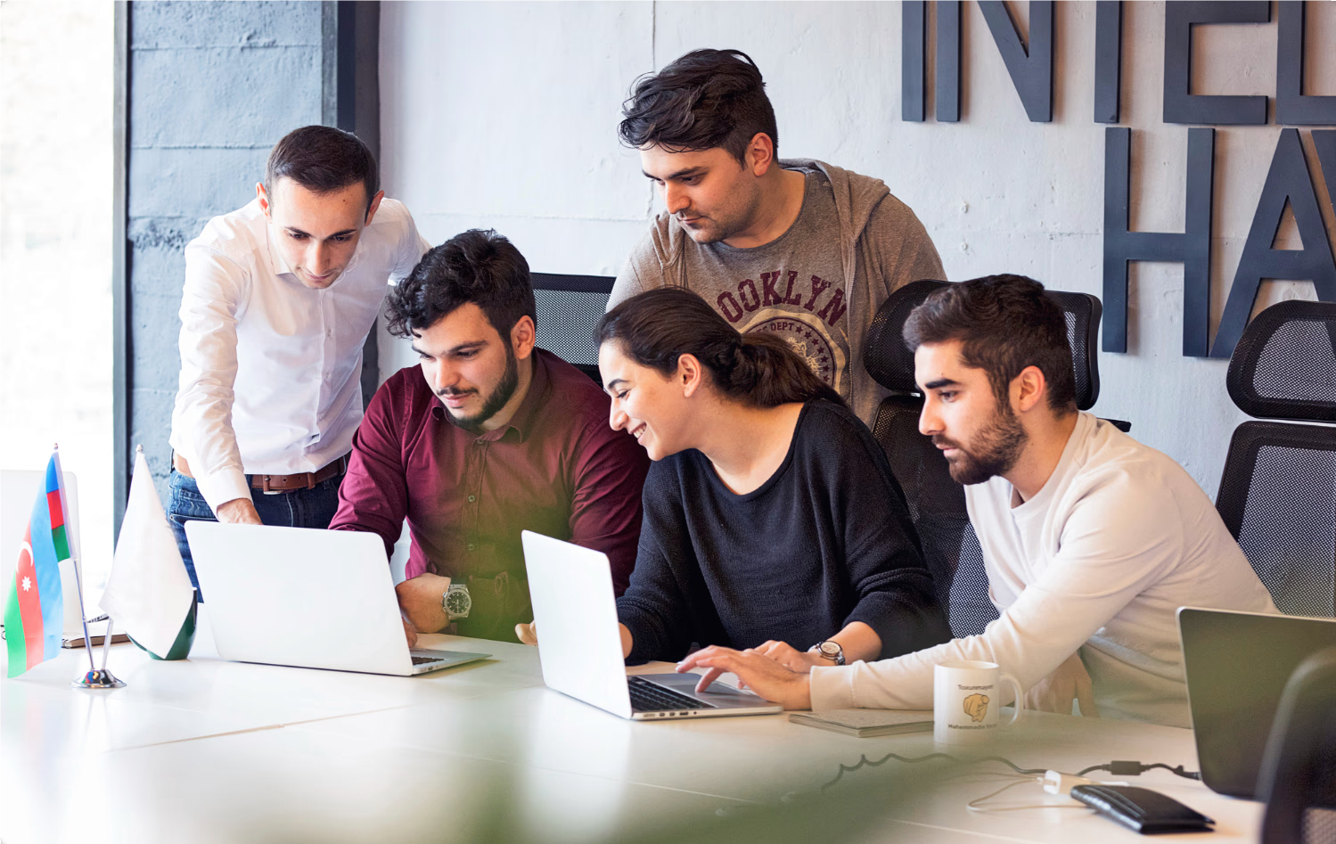 Product team collaborating around a laptop in a bright office